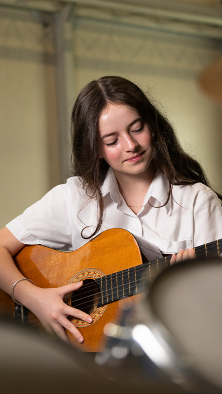 St Clare's Hassall Grove student playing guitar