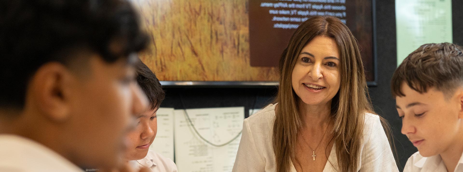 St Clare's Hassall Grove Teacher assisting group of students in class