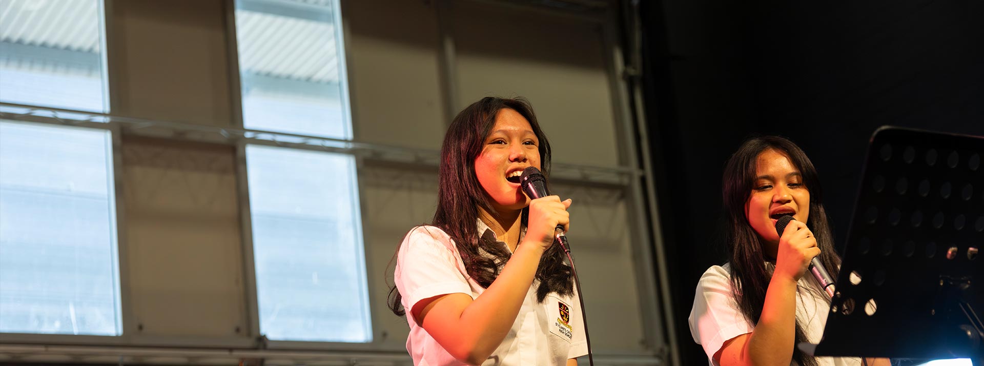 St Clare's Hassall Grove students singing into microphone