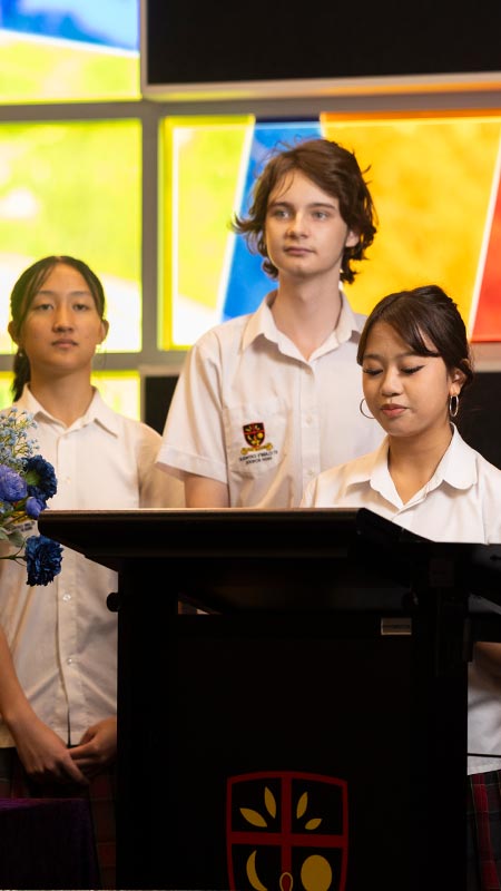 St Clare's Hassall Grove students speaking at podium in Church