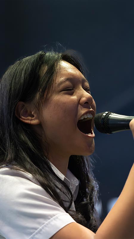 St Clare’s Hassall Grove student singing with intensity into a microphone