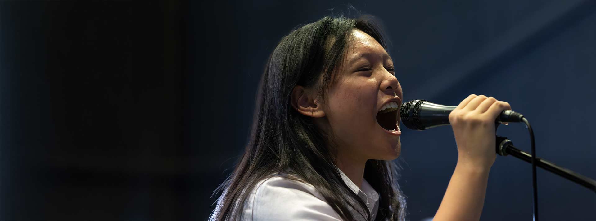 St Clare’s Hassall Grove student singing with intensity into a microphone