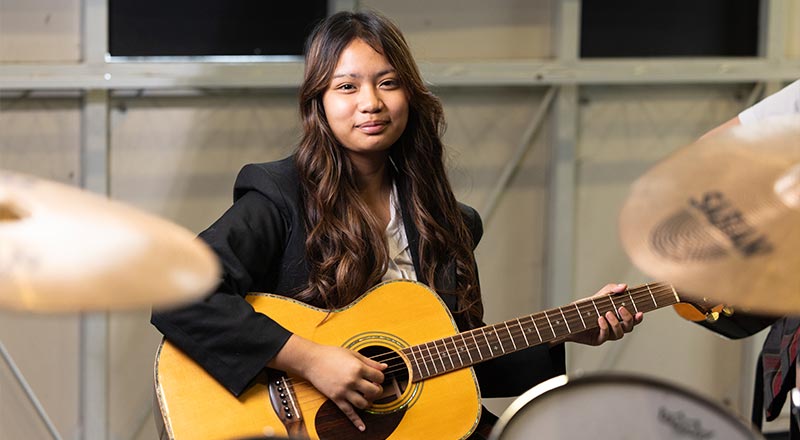 St Clare’s Hassall Grove students performing, playing guitar