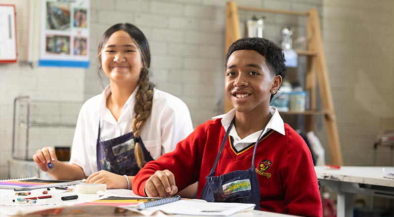 St Clare's Hassall Grove Teacher assisting group of students in art class