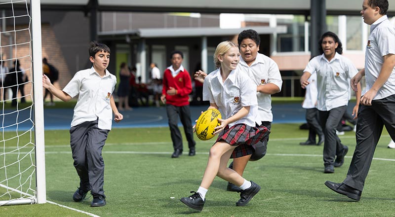 St Clare's Hassall Grove students playing soccer on school sports field