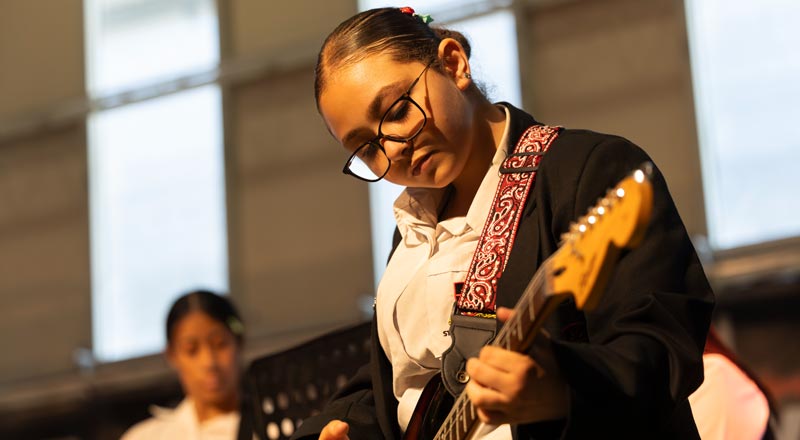 St Clare's student playing guitar