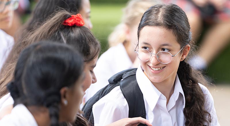 Smiling student sitting outdoors at St Clare's Hassall Grove