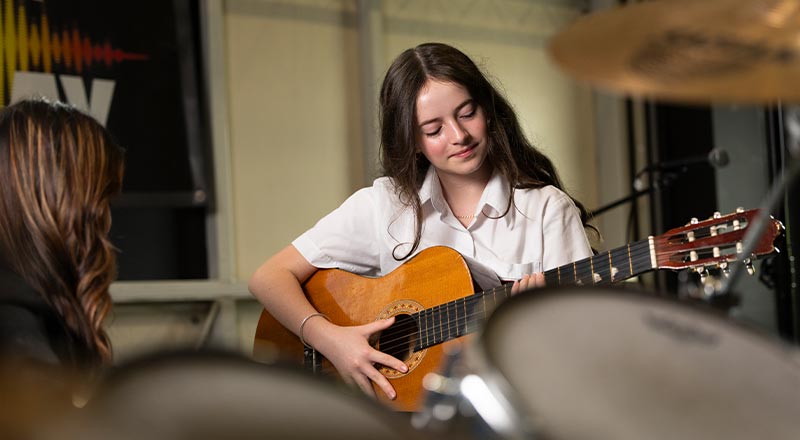 St Clare's Hassall Grove student playing guitar
