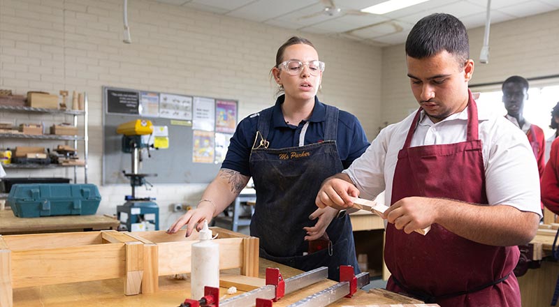 St Clare's woodwork teacher assisting her students 