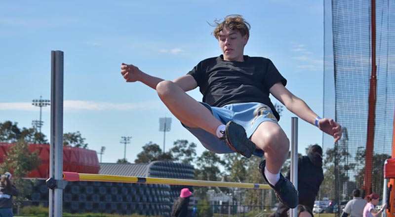 Photo from the 2025 Athletics Carnival, photo of St Clare's student jumping over the high jump pole