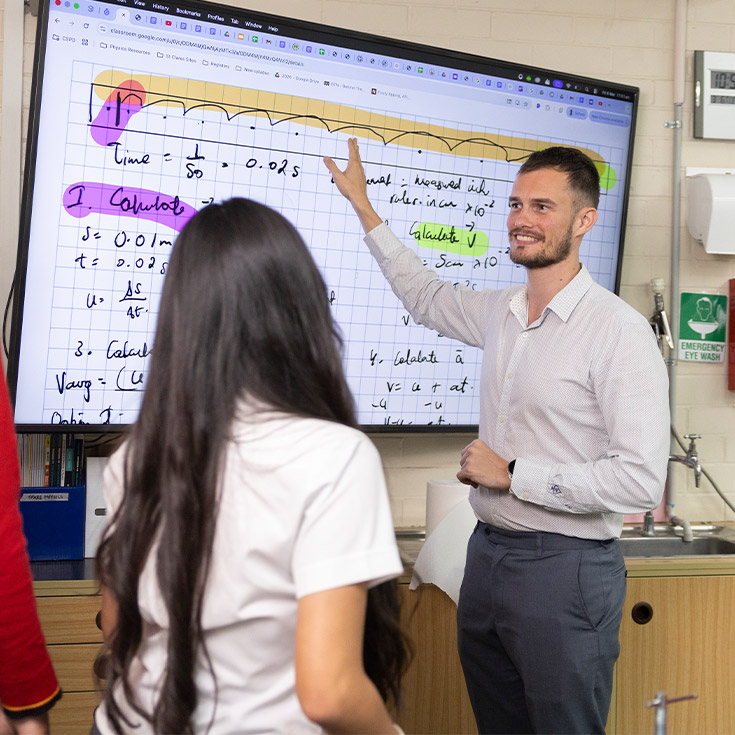 St Clare's Hassall grove teacher pointing to screen with maths equations